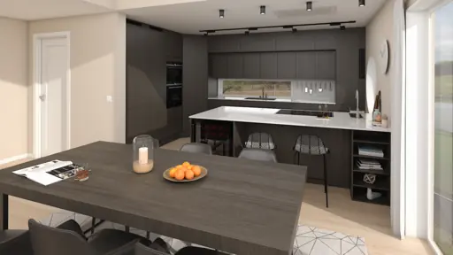 Interiör av modernt kök med mörka skåp, stort bord och ljusa ytor.